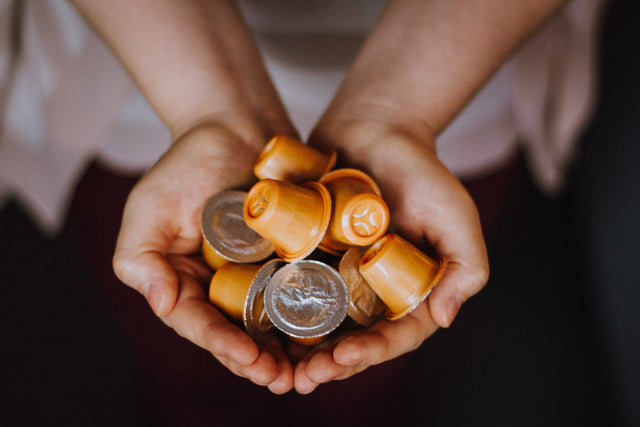 woman holding a handful of coffee capsules